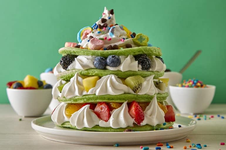 Lucky Charms™ Cereal Pancakes stacked in tiers with fresh fruit and cream in between.