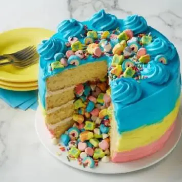 Instagram post featuring Lucky Charms™ Leprechaun Rainbow Layer Cake sliced open to expose cereal filling. - Link to social post