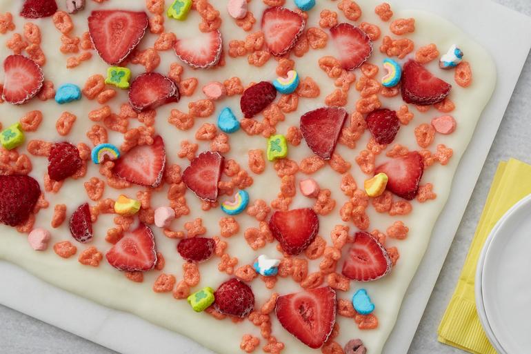 Receta de cortezas de frutas con yogur congelado de Lucky Charms™ servida con fresas en una bandeja de hornear.