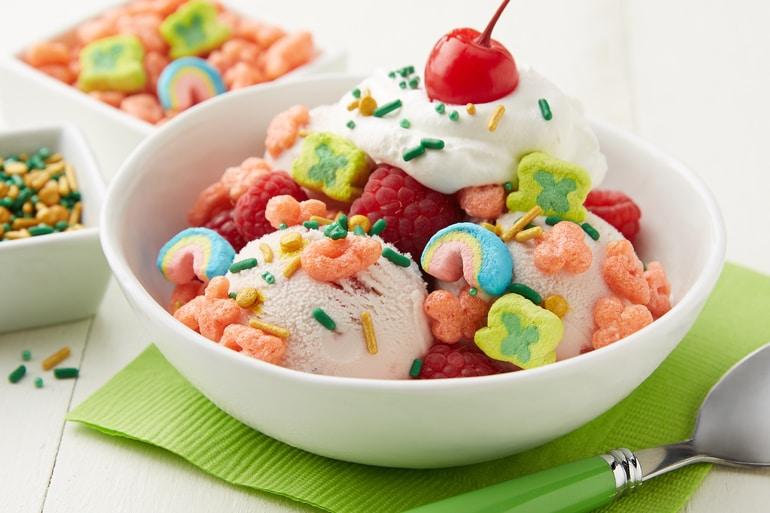 Un bol de helado, fresas, arándanos y Lucky Charms™ para preparar la receta de sundae de bayas de Lucky Charms™.