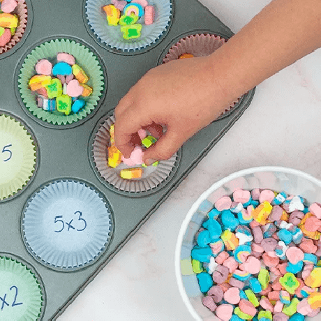 Los Lucky Charms™ magically delicious marshmallows añadidos a un molde de hornear para preparar Magically Delicious Lucky Charms™ Cereal Cookies.