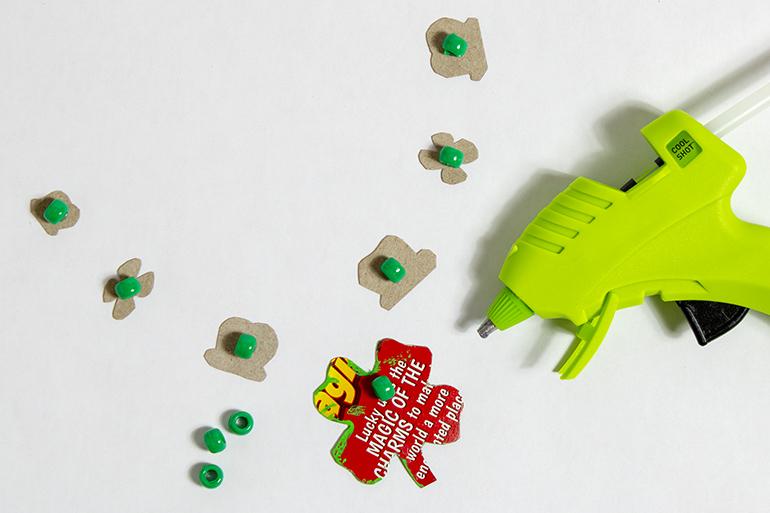 Un primer plano del juego de mesa Lucky's Leprechaun Trap con los jugadores moviéndose por el tablero. Una bola se mueve por las escaleras en el centro.