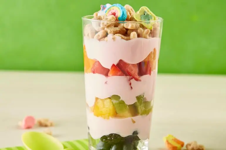 Rainbow Fruit Parfait in a clear glass with layers of yogurt, fruit and Lucky Charms™ cereal.