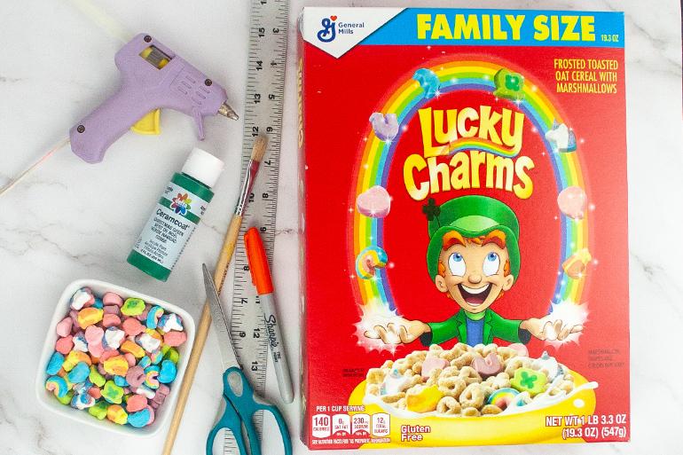 The materials needed for the Lucky Charms cereal box Christmas tree activity