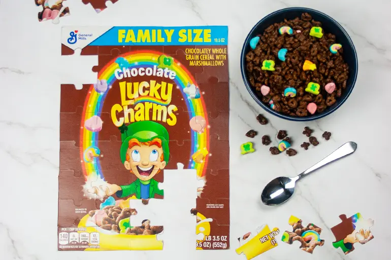 Lucky Charms magical cereal box puzzle with a bowl of chocolate Lucky Charms beside the activity