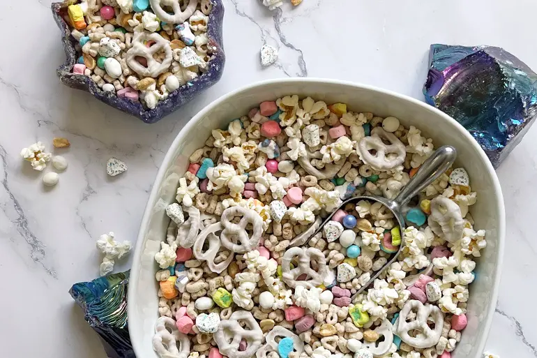 Overhead shot of Lucky Charms™ Magic Gems Trail Mix in bowls next to purple decorative crystals.