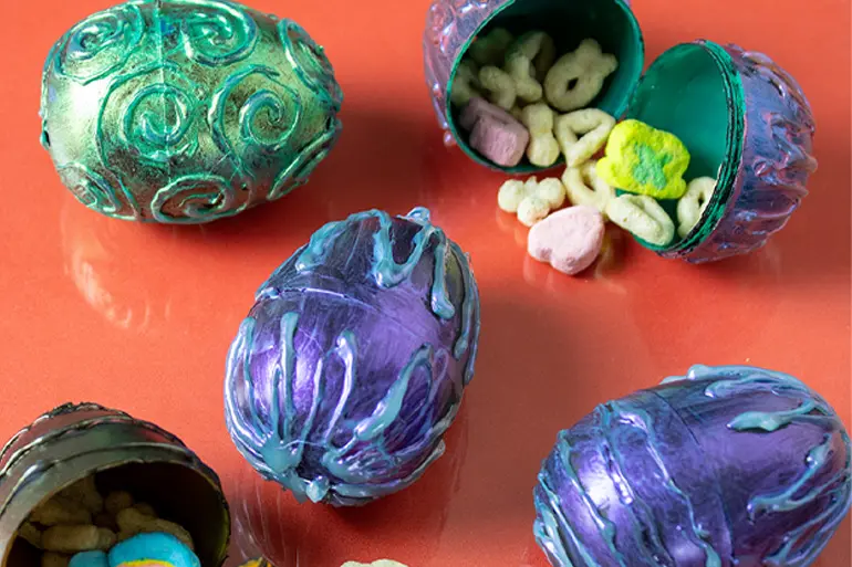 Five colorful Lucky Charms™ plastic Dragon Eggs with one open to reveal cereal pieces inside.