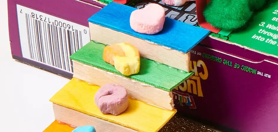 Pieces of Lucky Charms marshmallows sitting on colorful steps of a homemade leprechaun trap